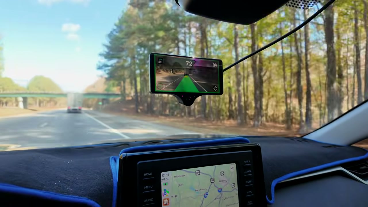 A Comma 3X on the windshield of a 2021 RAV4 Hybrid, showing the road ahead while driving