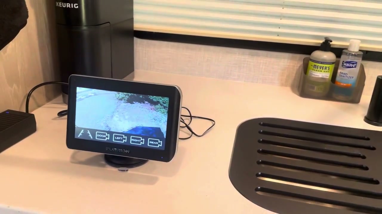 A Furrion Vision S monitor on the counter inside a travel trailer, showing the live view from an outside camera