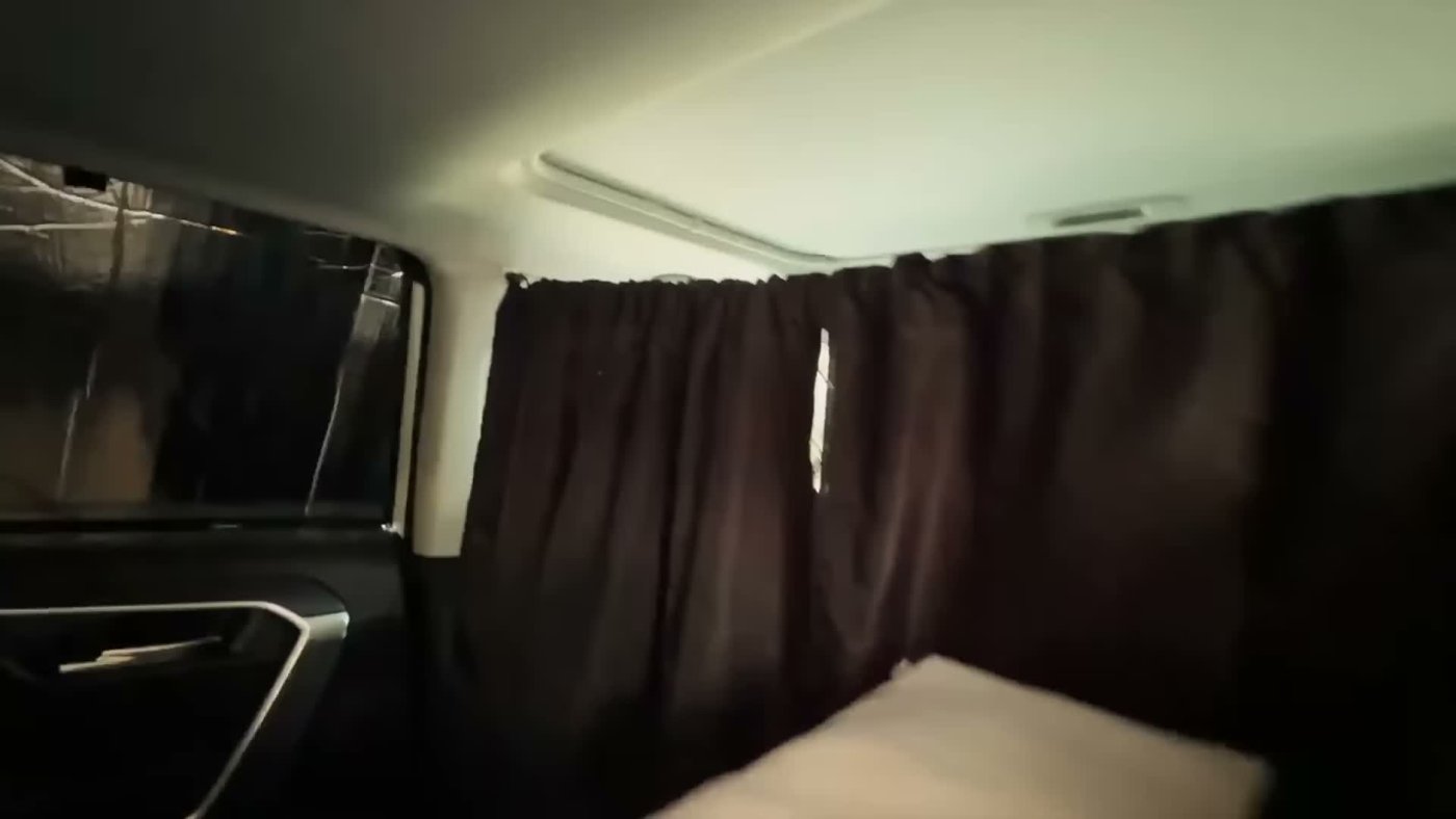 A dark blackout curtain hung across a RAV4 behind the front seats, with covered rear windows