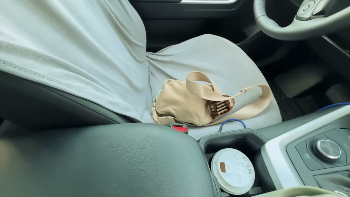 A RAV4 passenger seat covered with a towel, bags and a water bottle before being cleared