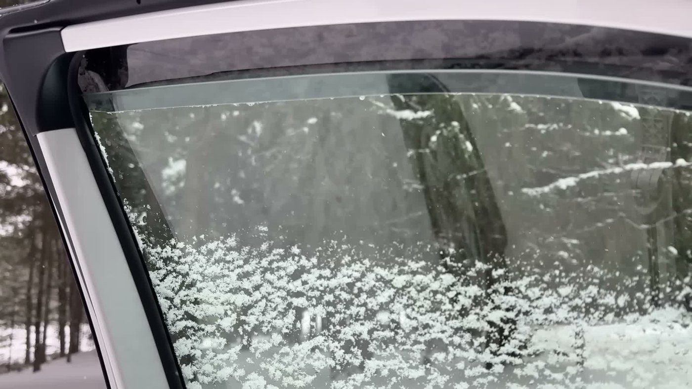 A RAV4 rear window cracked open about an inch under a window deflector, with snow outside