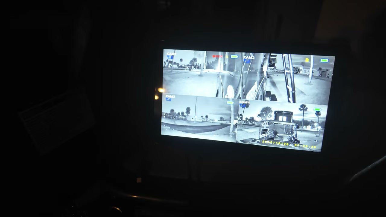 A 10-inch screen glowing in a dark motorhome cab, showing four camera views in night vision