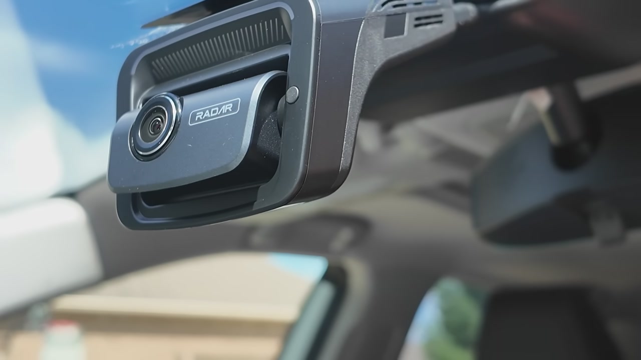 A Thinkware U3000 with its RADAR label, mounted on a windshield next to the mirror
