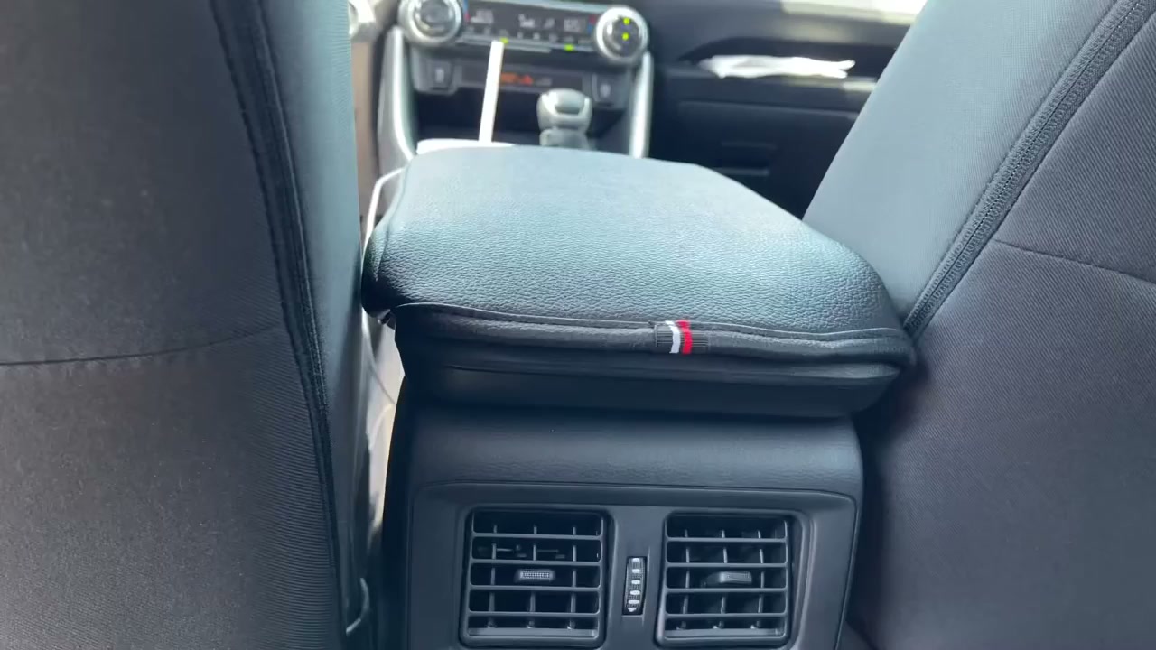 A black JDMCAR padded cover on the center console of a 2021 RAV4 XLE, seen from the back seat