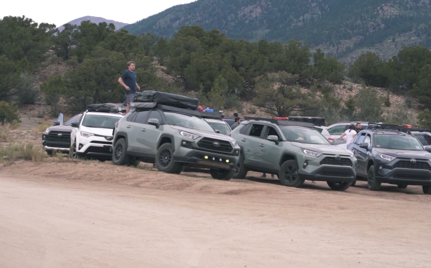 A row of owners' RAV4s, mostly 2019 and newer with roof racks and rooftop tents, parked together on a dirt lot in the mountains near Buena Vista, Colorado, at a 2020 owner meetup