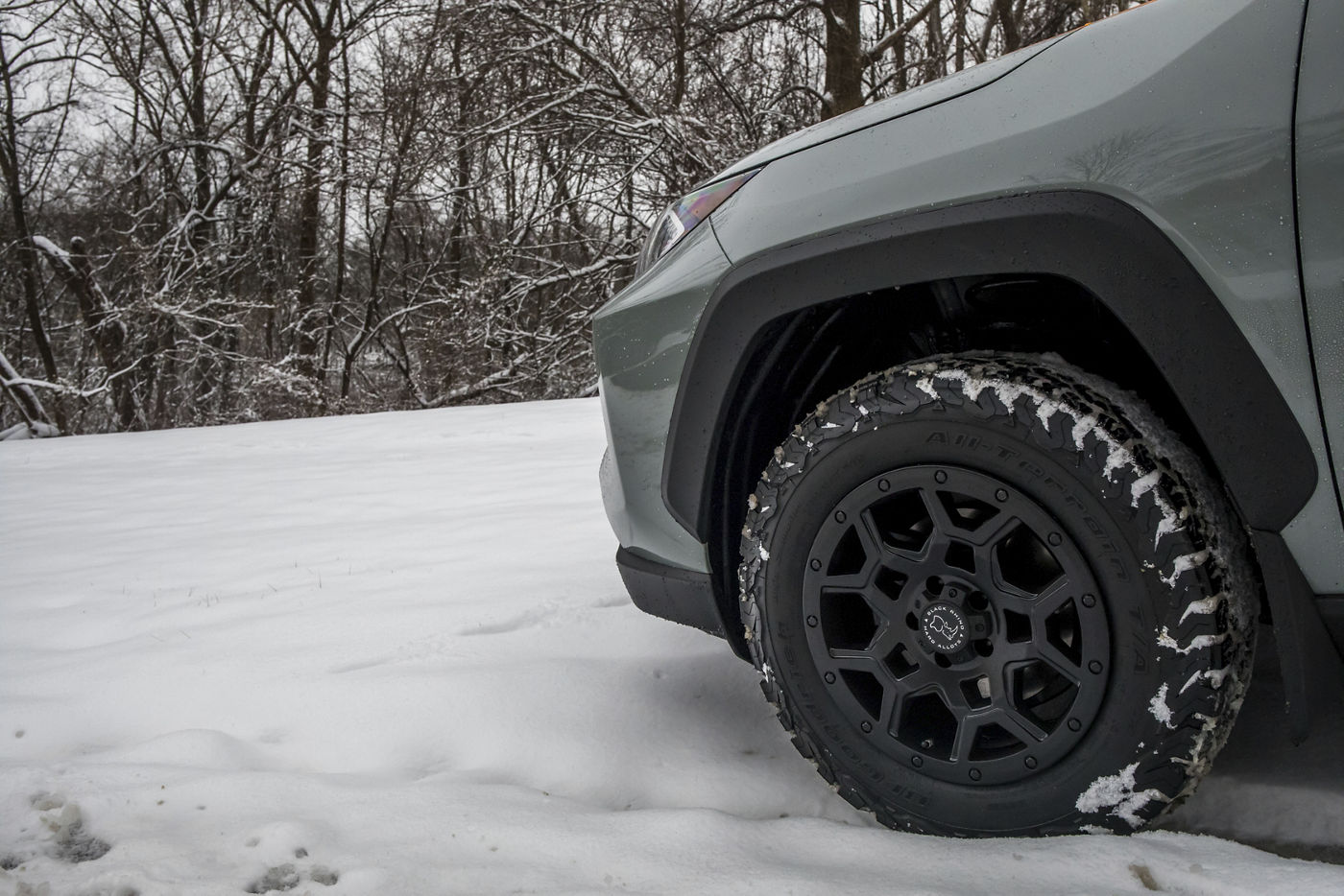 Close-up of the matte black Black Rhino Overland wheel and all-terrain tire in snow