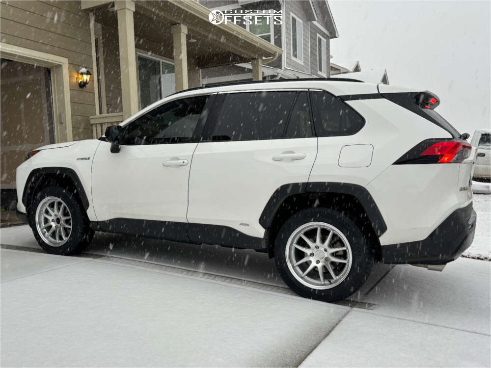 Side view of the white RAV4 Hybrid on silver Aodhan DS02 wheels in light snow