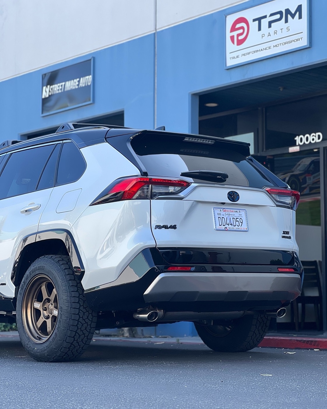 Rear three-quarter view of the white Hybrid XSE on bronze TE37s