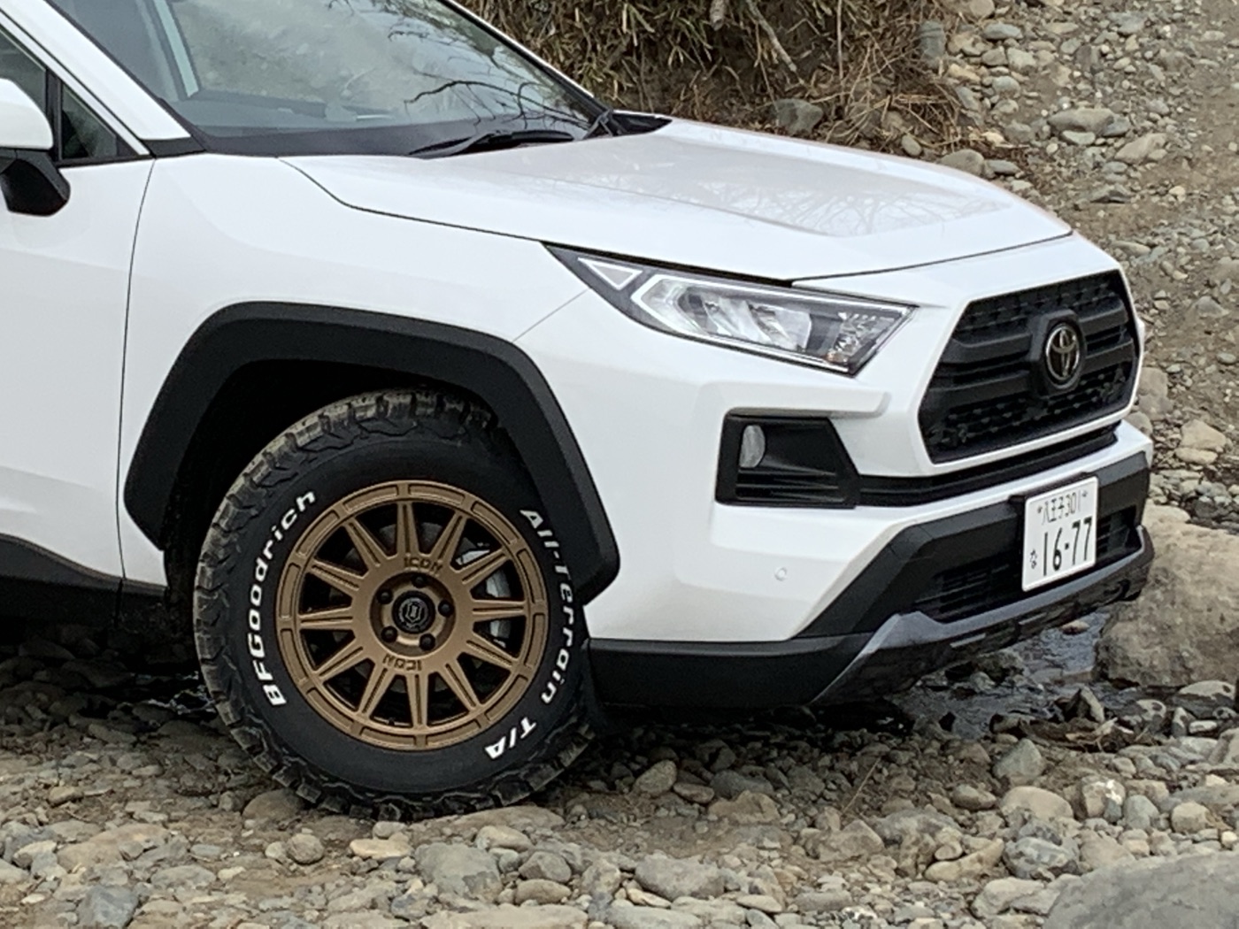 Front view of the white RAV4 on satin gold Ricochet wheels