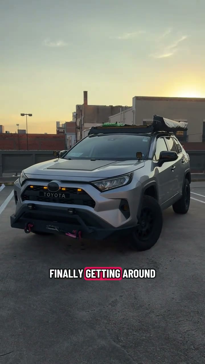 A lifted silver RAV4 XLE with a custom front bumper, roof rack and lights, on black wheels and Falken Wildpeak A/T tires